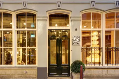 a store front with black doors and windows at Hotel V Nesplein in Amsterdam