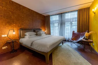 a bedroom with a large bed and a large window at Hotel V Nesplein in Amsterdam