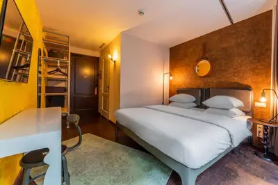 a bedroom with a large white bed in a room at Hotel V Nesplein in Amsterdam