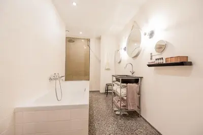 a bathroom with a tub and a sink at Hotel V Nesplein in Amsterdam