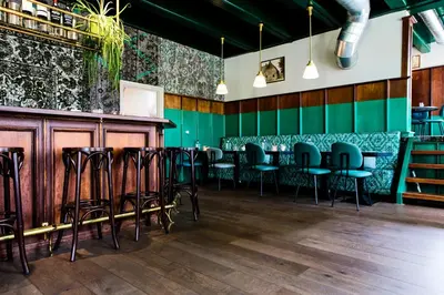 a row of chairs in a restaurant with green walls at De Buren in Vleuten