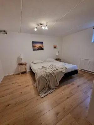 a bedroom with a bed with a blanket on it at Amsterdam Beach in Zandvoort
