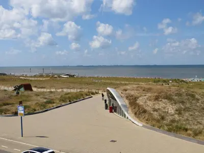 a sidewalk next to a beach with the ocean at Appartementen Zeezicht - 1 in Katwijk aan Zee