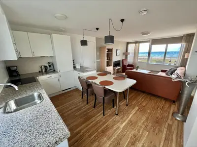 a kitchen and living room with a table and a couch at Appartementen Zeezicht - 1 in Katwijk aan Zee