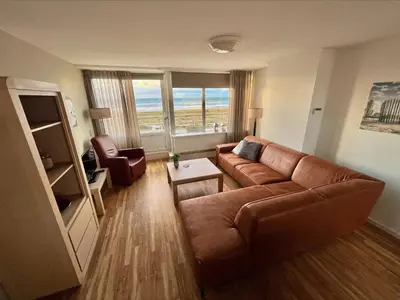 a living room with a couch and a chair at Appartementen Zeezicht - 1 in Katwijk aan Zee
