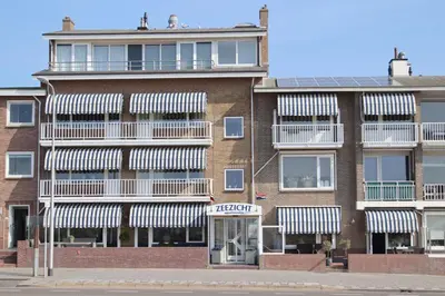 an apartment building with white awnings on it at Appartementen Zeezicht - 3 in Katwijk aan Zee