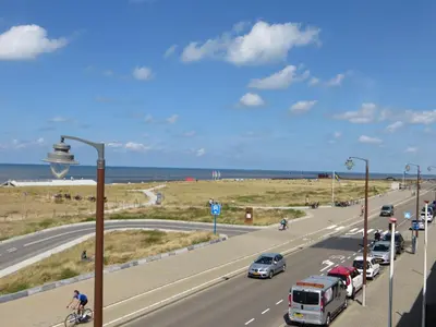 a highway with cars and a cyclist and a bus at Appartementen Zeezicht - 3 in Katwijk aan Zee
