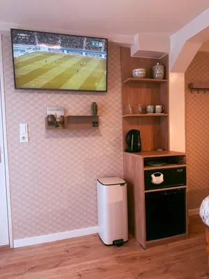 a living room with a tv hanging on a wall at Garden Room or Economy Room in Amsterdam