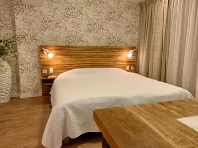 a bedroom with a white bed and a wooden headboard at Garden Room or Economy Room in Amsterdam