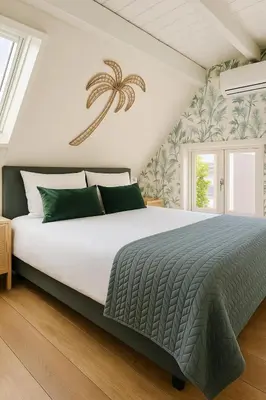 a bedroom with a large white bed with green pillows at Villa Hop Zandvoort in Zandvoort