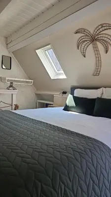 a bedroom with a bed with a palm tree on the wall at Villa Hop Zandvoort in Zandvoort