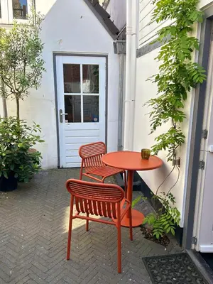 a red table and two chairs next to a door at Villa Hop Zandvoort in Zandvoort