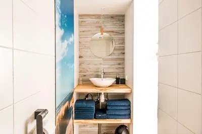 a bathroom with a sink and blue towels at Villa Hop Zandvoort in Zandvoort