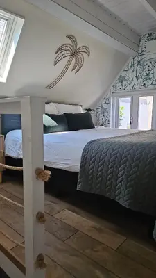 a bedroom with a bed with a sign on the wall at Villa Hop Zandvoort in Zandvoort