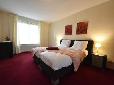 a bedroom with a large bed with a red carpet at Family Home in Zeewolde by Forest Trails in Zeewolde
