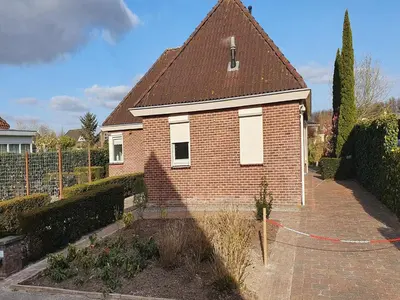 a small brick house with a red roof at Family Home in Zeewolde by Forest Trails in Zeewolde