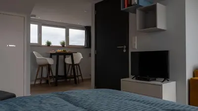 a bedroom with a bed and a television and a table at Appartementen De Boulevard in Zandvoort