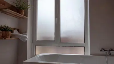 a bath tub in a bathroom with a window at Appartementen De Boulevard in Zandvoort