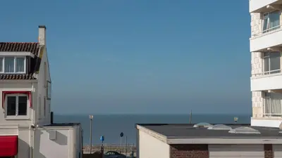 a view of the ocean from between two buildings at Appartementen De Boulevard in Zandvoort
