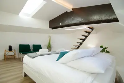 a bedroom with a bed with white pillows and a staircase at Eco HouseBoat in Amsterdam