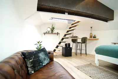a living room with a leather couch and a loft at Eco HouseBoat in Amsterdam