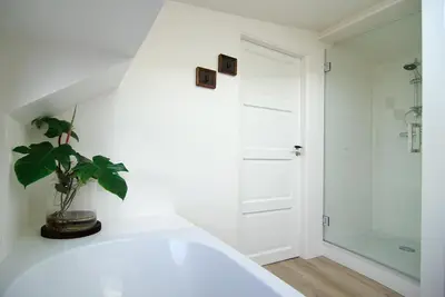 a bathroom with a white tub and a potted plant at Eco HouseBoat in Amsterdam