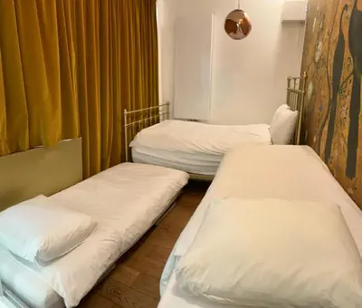 two beds in a hospital room with yellow curtains at BEAUTIFUL APARTMENT WiTH ASIAN STYLE BEDROOM NEAR RAI & CENTER in Amsterdam