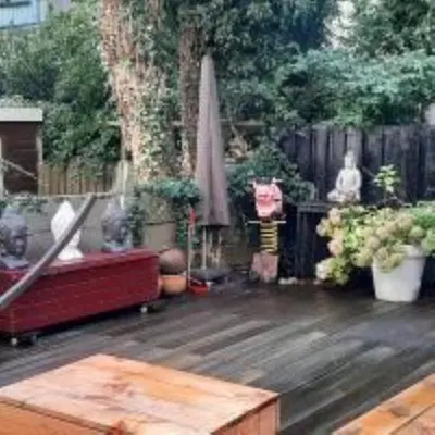 a patio with a couch and a umbrella and plants at BEAUTIFUL APARTMENT WiTH ASIAN STYLE BEDROOM NEAR RAI & CENTER in Amsterdam