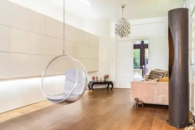 a living room with a swinging chair and a couch at BEAUTIFUL APARTMENT WiTH ASIAN STYLE BEDROOM NEAR RAI & CENTER in Amsterdam