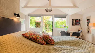 a bedroom with a bed with pillows and a window at Studio Clematis in Bergen