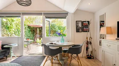 a kitchen and living room with a table and chairs at Studio Clematis in Bergen