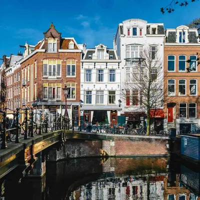 a bridge over a river in a city with buildings at Amsterdam Wiechmann Hotel in Amsterdam