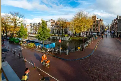 a person riding a bike on a city street at Amsterdam Wiechmann Hotel in Amsterdam