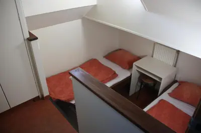 a small room with two beds and a table at Hotelschip Gandalf in Amsterdam