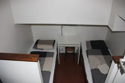 a small room with three bunk beds and a desk at Hotelschip Gandalf in Amsterdam