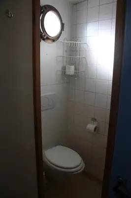 a small bathroom with a toilet and a light at Hotelschip Gandalf in Amsterdam