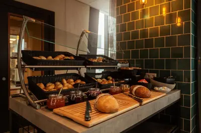 a buffet with bread and pastries on a table at Holiday Inn - the niu, Fender Amsterdam in Amsterdam