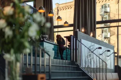 a woman walking down the stairs of a building at Holiday Inn - the niu, Fender Amsterdam in Amsterdam