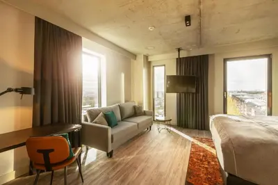 a bedroom with a couch and a bed and a desk at Holiday Inn - the niu, Fender Amsterdam in Amsterdam
