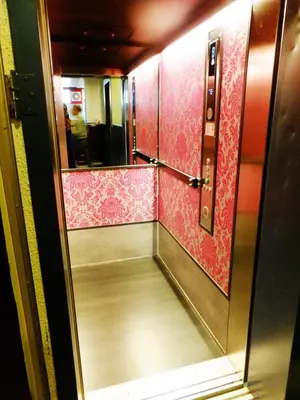an empty hallway in a train with pink wallpaper at Flying Pig Downtown in Amsterdam