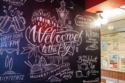 a chalkboard wall with a welcome to the pros sign at Flying Pig Uptown in Amsterdam