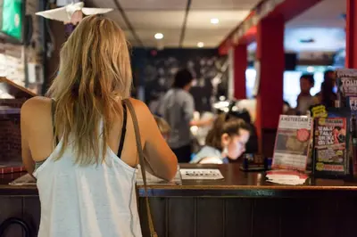 a woman standing at a counter in a restaurant at Flying Pig Uptown in Amsterdam
