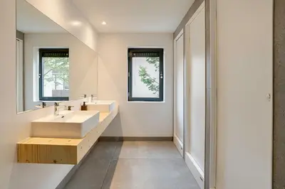a bathroom with two sinks and two windows at St Christopher's Inn Amsterdam - The Winston in Amsterdam
