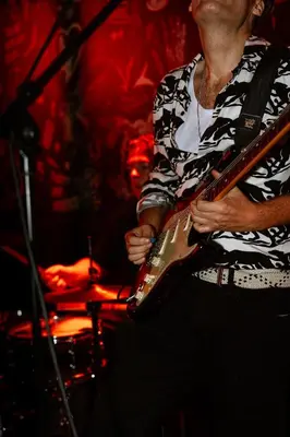 a man playing a guitar on a stage at St Christopher's Inn Amsterdam - The Winston in Amsterdam