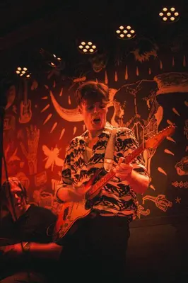a man playing a guitar in a room at St Christopher's Inn Amsterdam - The Winston in Amsterdam