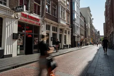 a city street with people walking down a street at St Christopher's Inn Amsterdam - The Winston in Amsterdam