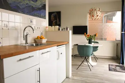 a kitchen with a sink and a table with a chair at The New Lake Boathouse in Amsterdam