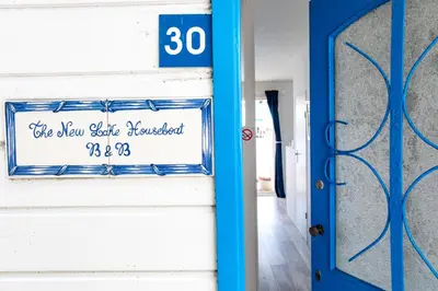 a blue door and a sign on a wall at The New Lake Boathouse in Amsterdam