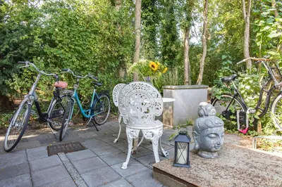 a patio with a statue of a head and bikes at The New Lake Boathouse in Amsterdam