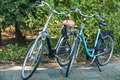 two bikes parked next to each other on a sidewalk at The New Lake Boathouse in Amsterdam